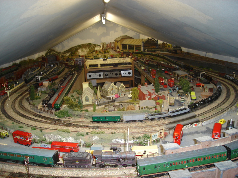 A busy layout 2 loops upper and lower;single upward on right ;single downward on extreme left.About 24ft from camera and another 6x4 ft behind to right Interpretation of Cannon Street on back right